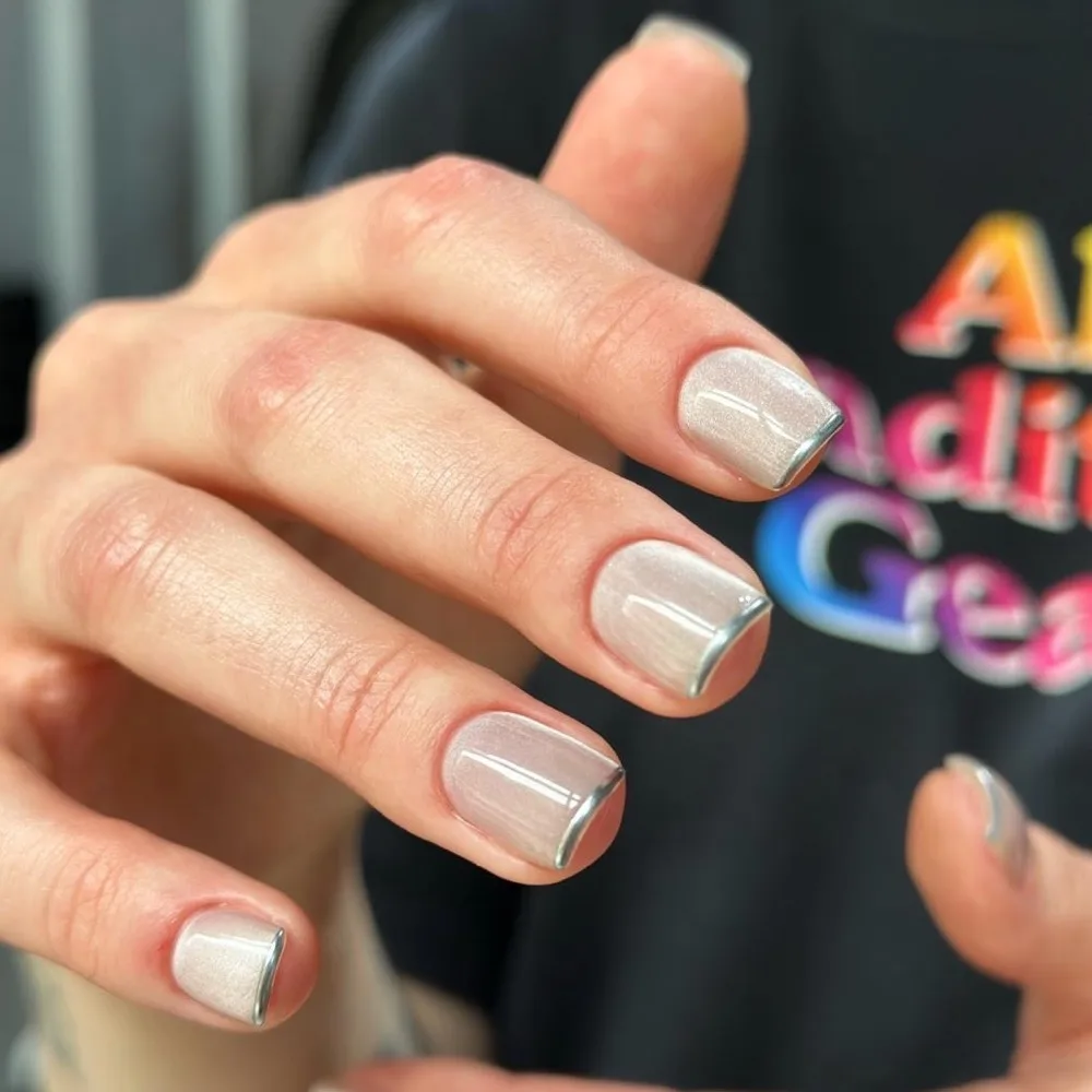 Perłowy manicure hybrydowy ze srebrnym french tipem, wykonany w Norm